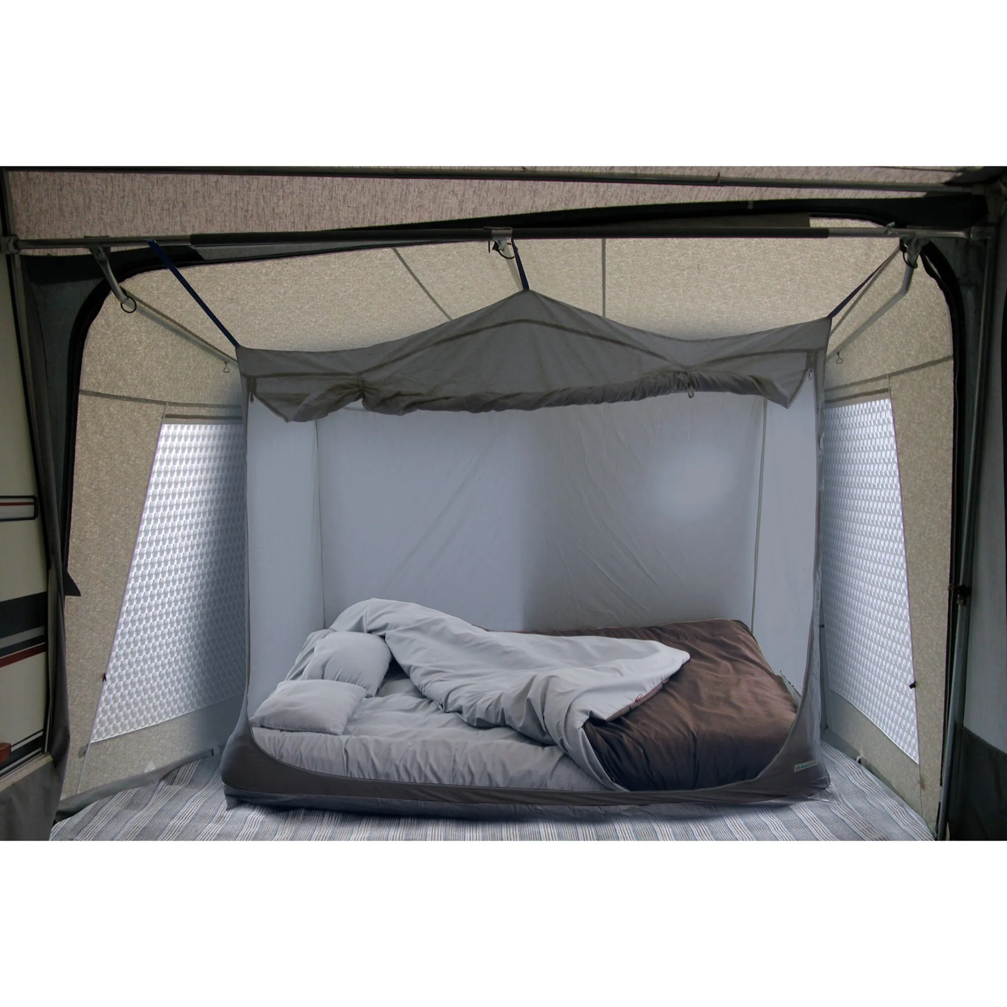 Innenansicht der grauen Schlafkabine mit aufgebautem Bett, Matratze, Kissen und zerwühlter Bettdecke