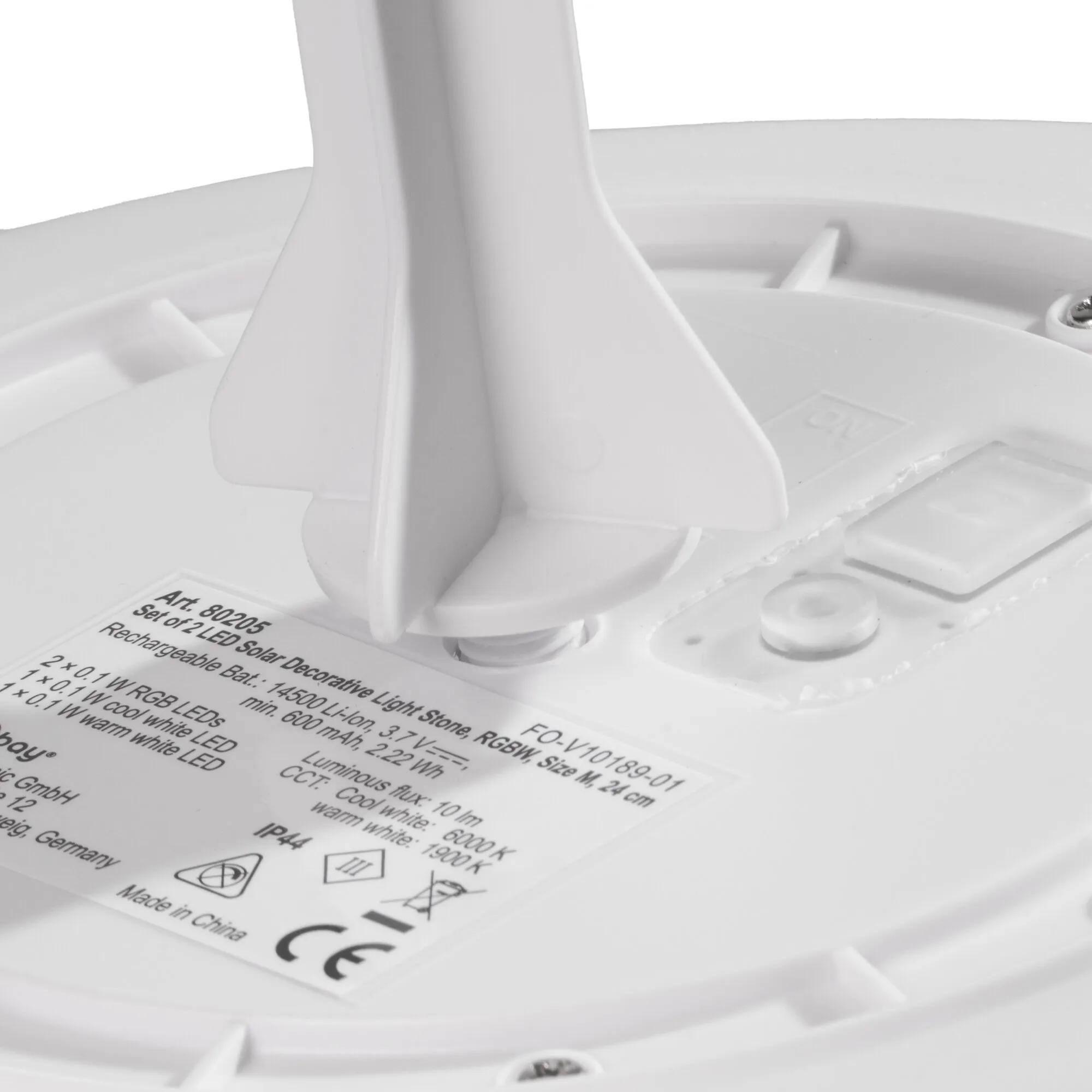 Detailaufnahme der weißen Unterseite eines LED-Solar-Dekosteins mit sichtbarer Technik und Produktetikett geg.