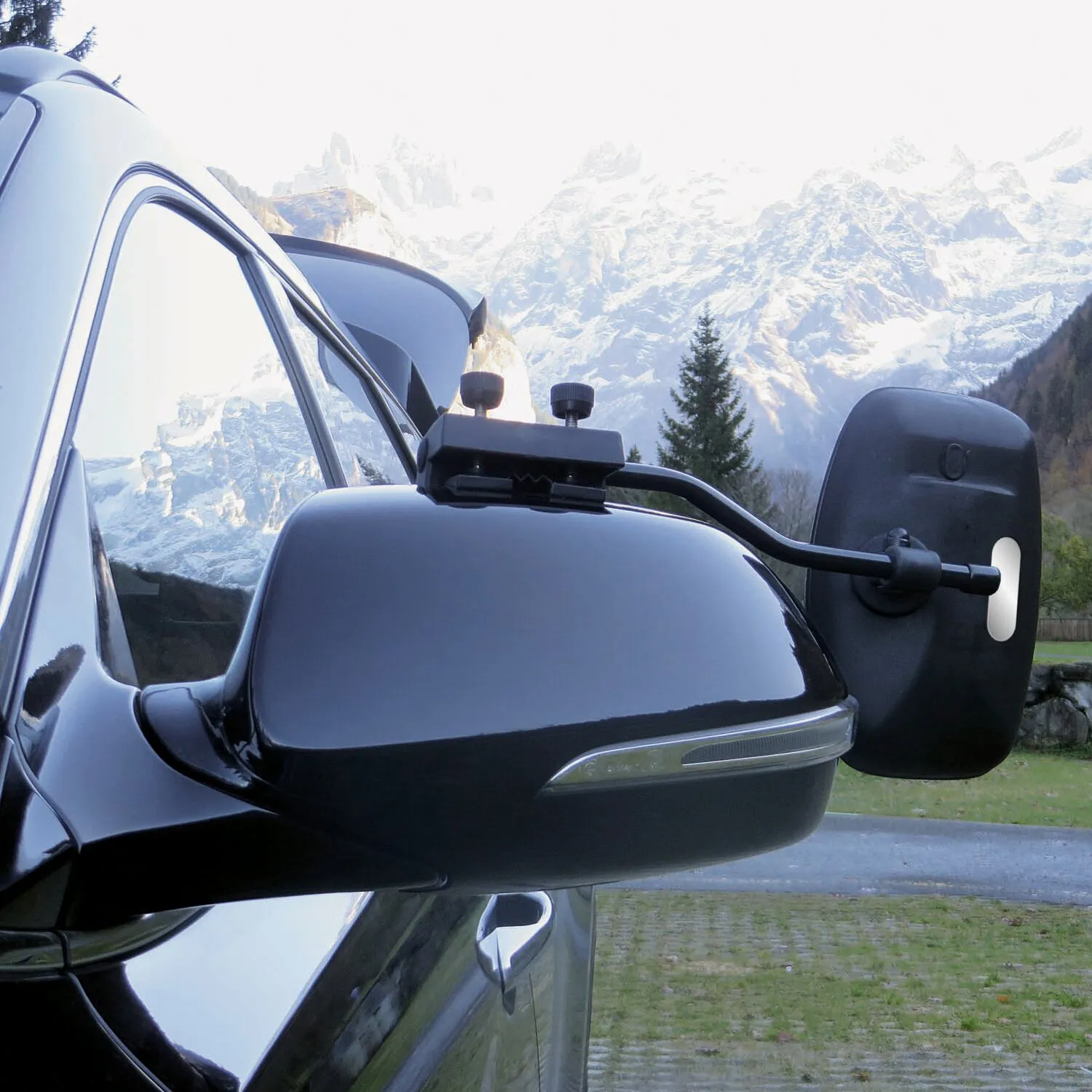Schwarzer Caravanspiegel Universa III PRO XL am Außenspiegel eines Fahrzeugs vor verschneiter Alpenkulisse