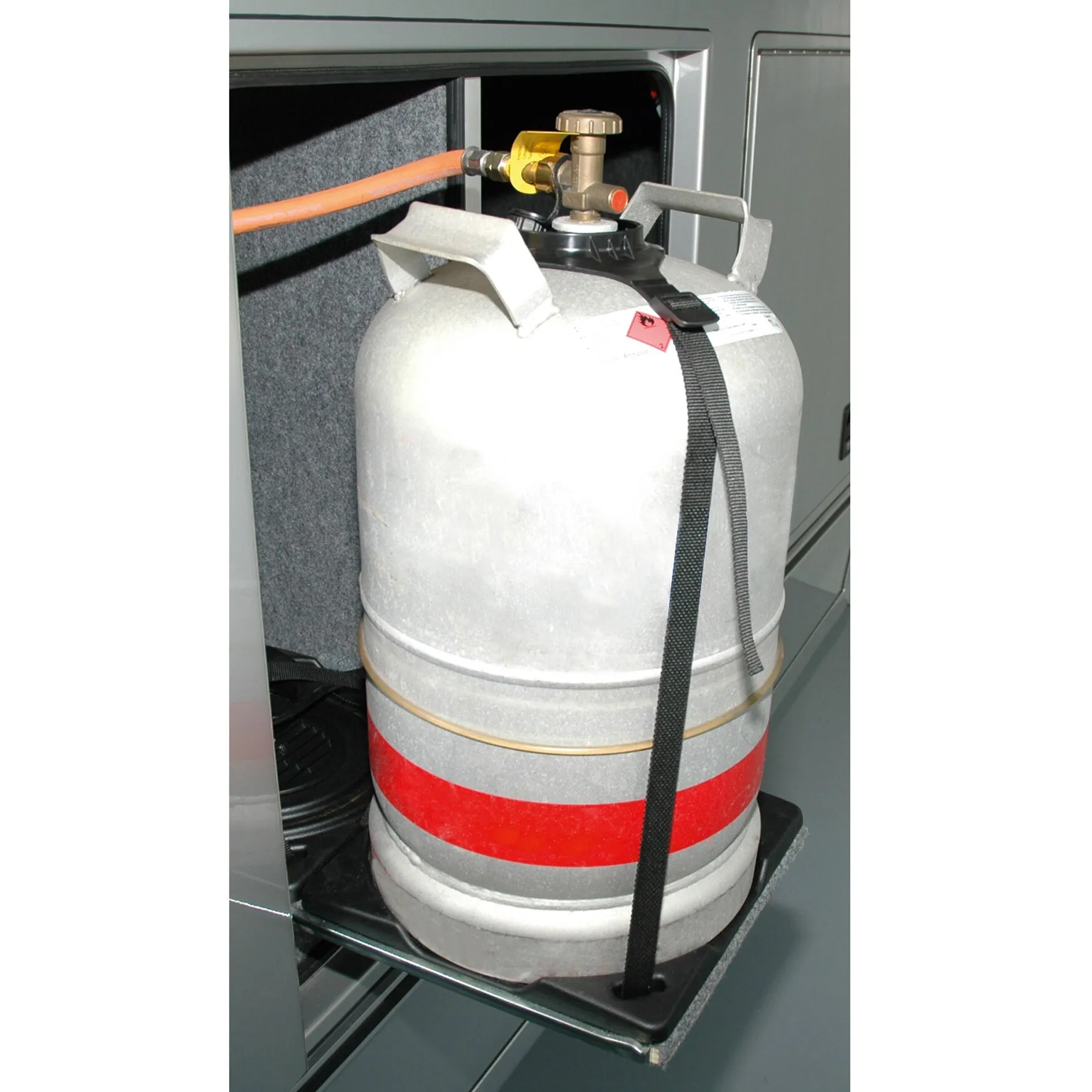 Gasflaschenhalter für eine große graue 11-kg-Gasflasche mit schwarzem Sicherungsgurt und Bodenhalterung im Fahrzeugfach