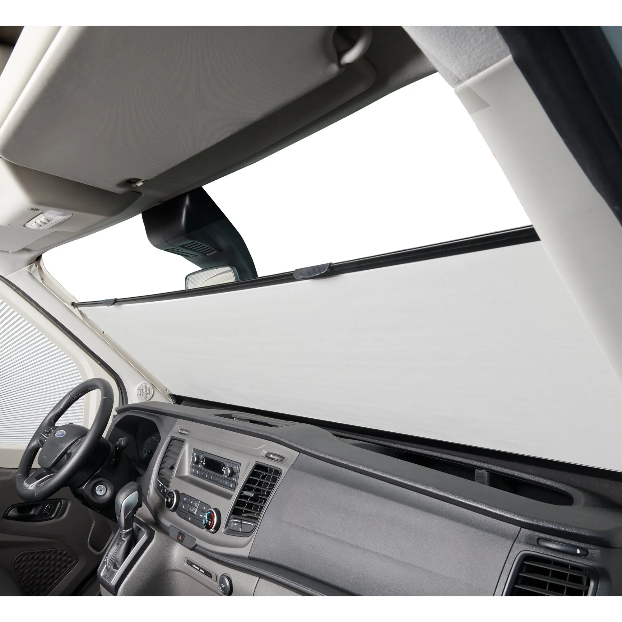 Innenansicht eines Ford Transit V363 mit montiertem hellgrauem Verdunkelungssystem an der Frontscheibe und sichtbarem Cockpit