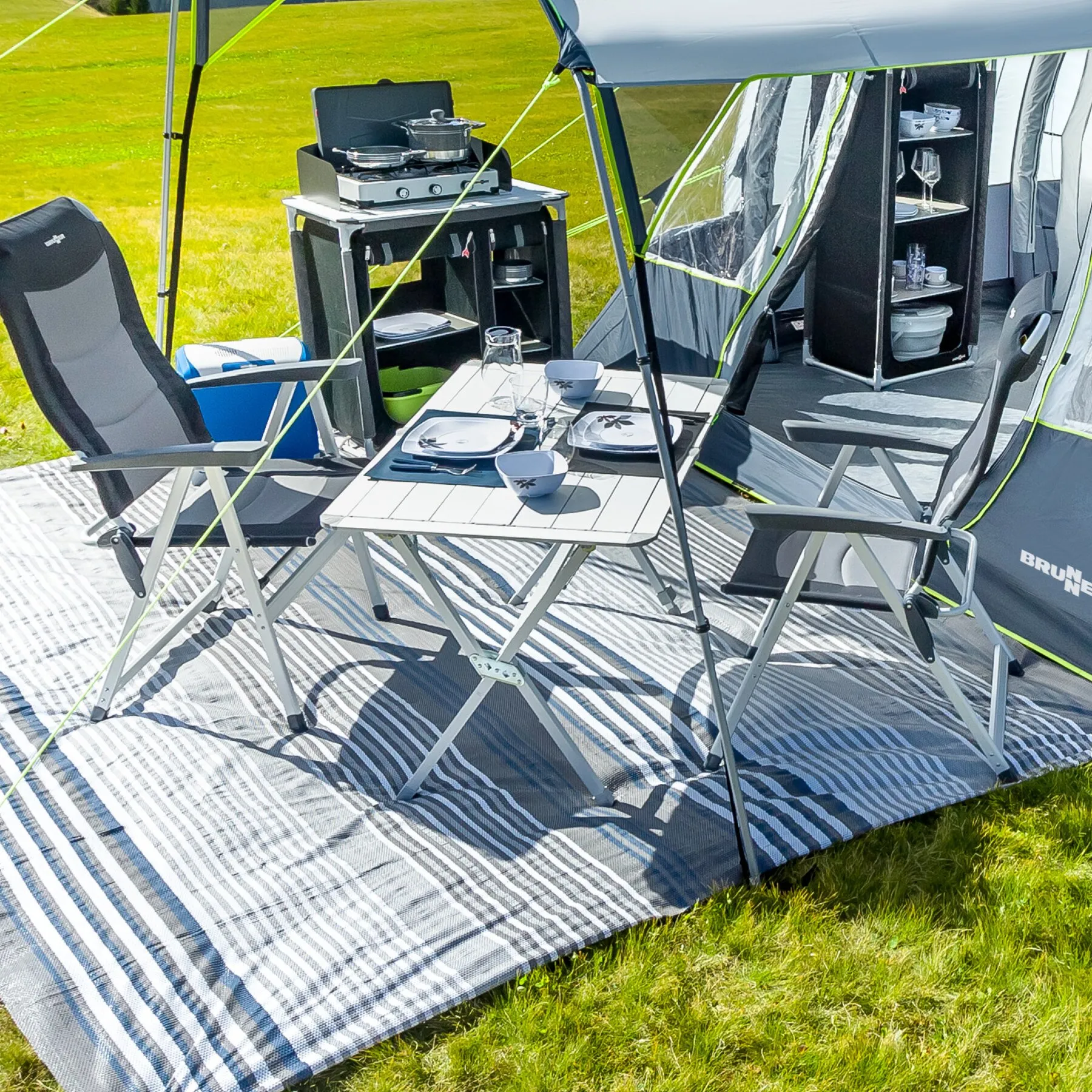 Silberner Rolltisch Silver Gapless, 140 cm, mit hellen Tischplattenleisten und Klappgestell, beim Camping mit Geschirr gedeckt