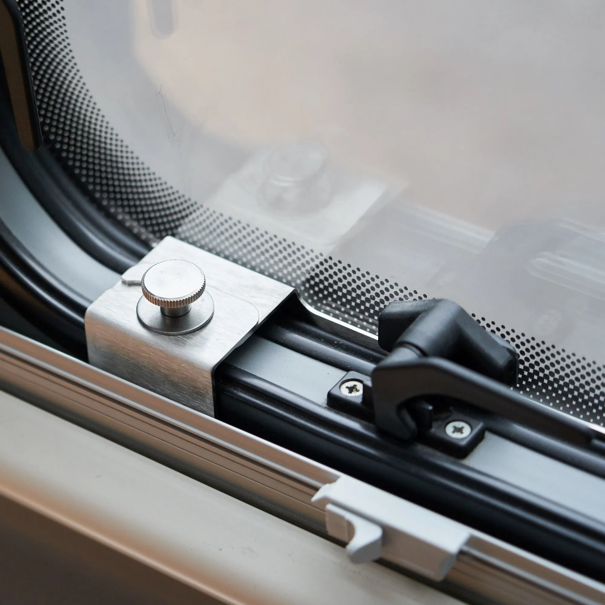 Detailaufnahme eines Sicherheitsprofils aus Aluminium mit Drehknopf und schwarzer Verriegelung am Ausstellfenster S10 Deluxe 1200