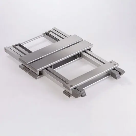 Silberner Metallrahmen eines Hocker Single mit parallel verlaufenden Schienen, querverbindenden Elementen und einer flachen Oberseite, auf weißem Hintergrund