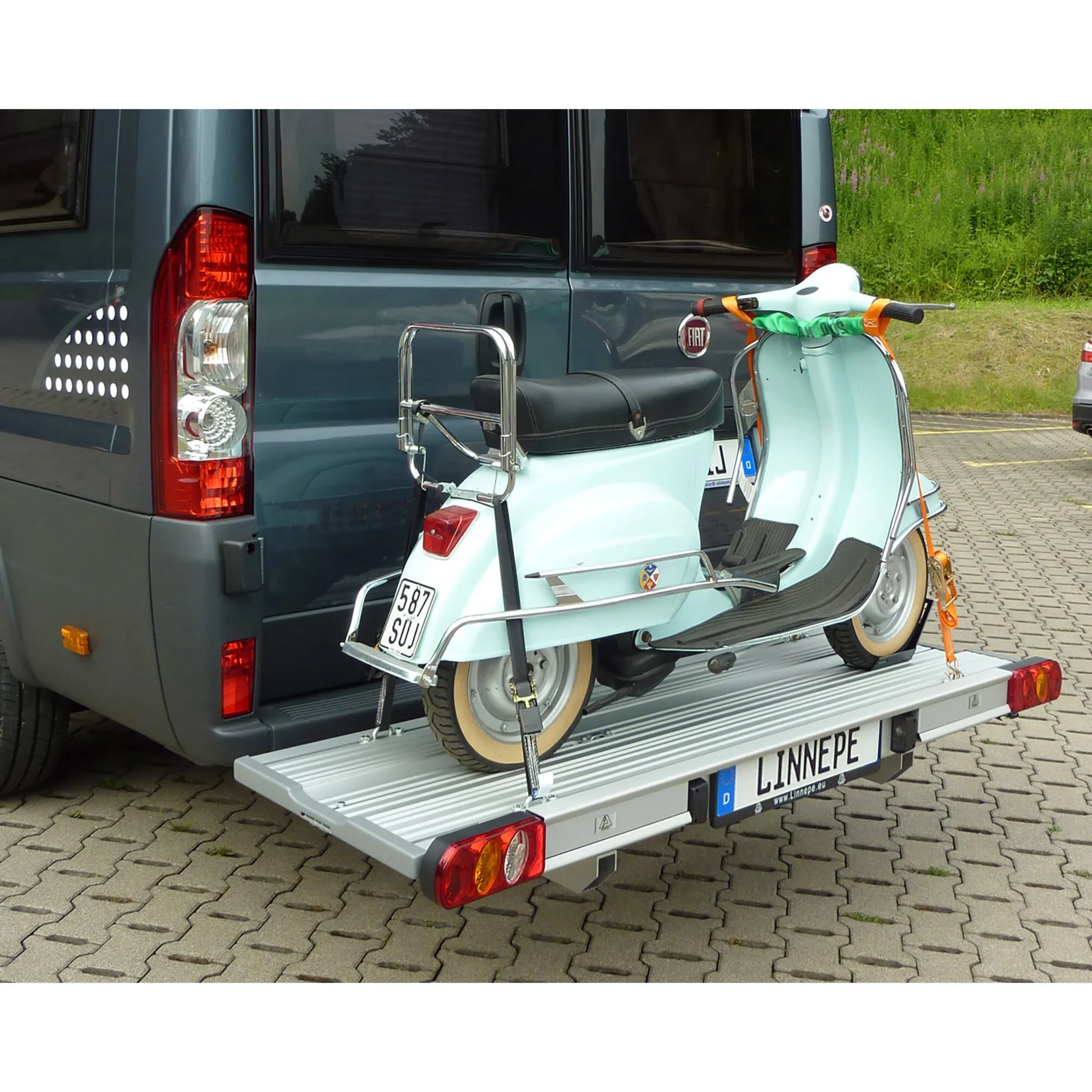 Linnepe SlidePort Lastenträger am Heck eines Fiat Ducato mit gesicherter mintgrüner Vespa auf der Aluminiumplattform