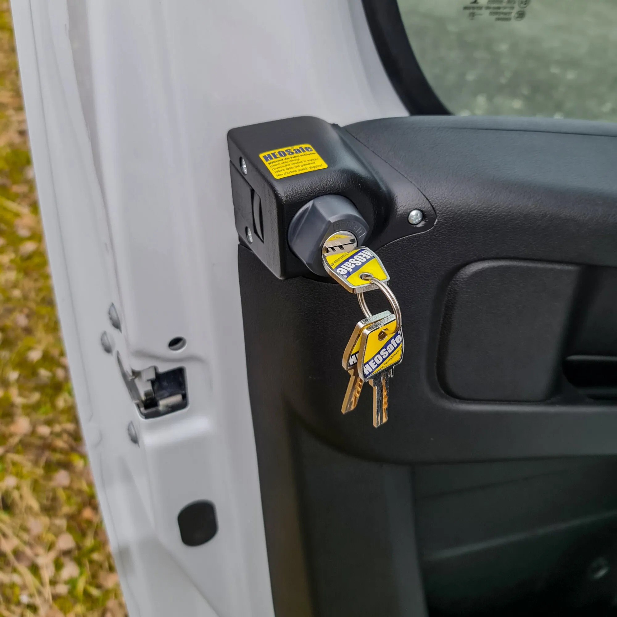 Schwarzes Diebstahlschutzschloss mit Schlüssel an der Fahrertür eines weißen Fiat Ducato X290 montiert