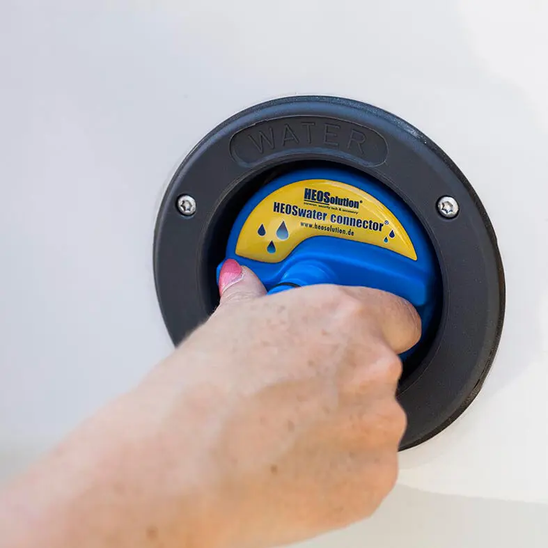 Schwarzer Wassertankdeckel HEOSwater Connector 5251 mit blauem Verschluss, der von einer Hand geöffnet wird