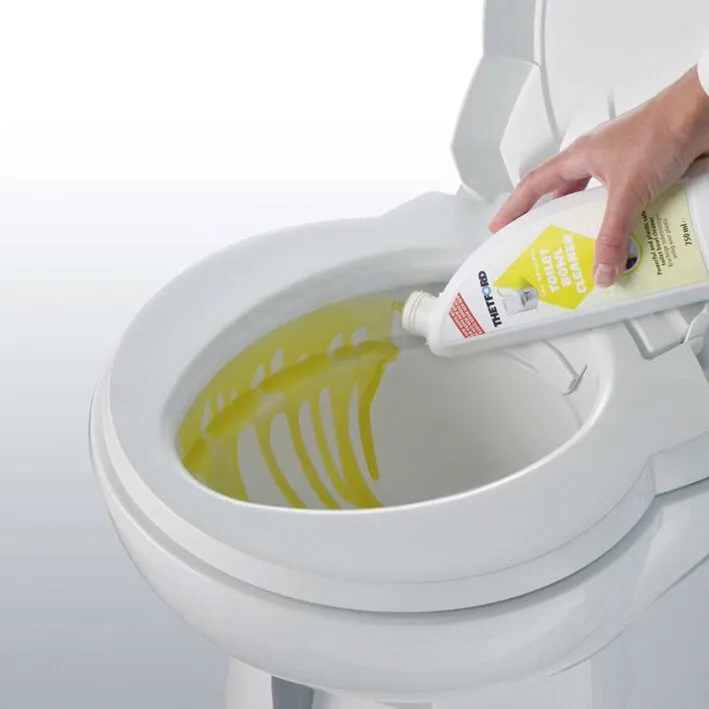 Hand gießt gelben Toilettenreiniger aus einer weißen Flasche in eine weiße Toilettenschüssel】【。