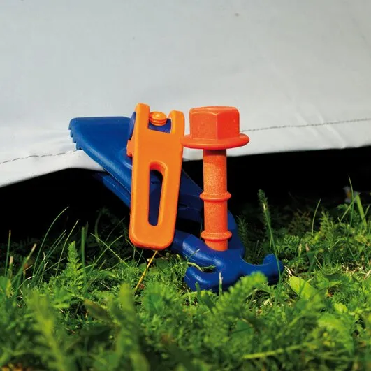 Schnellspannklemme PP Crocodile 4 in Blau und Orange befestigt eine weiße Plane im Gras