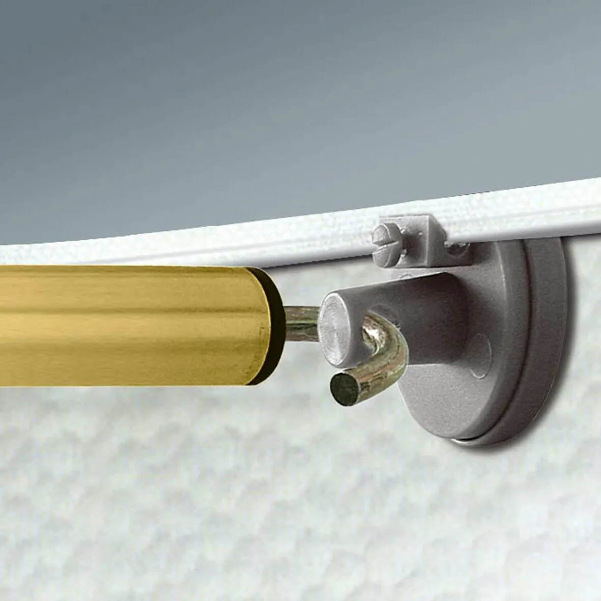 Detailaufnahme eines SHS Blockers an einer goldfarbenen Stange mit grauer Wandhalterung und gebogenem Sicherungsstift
