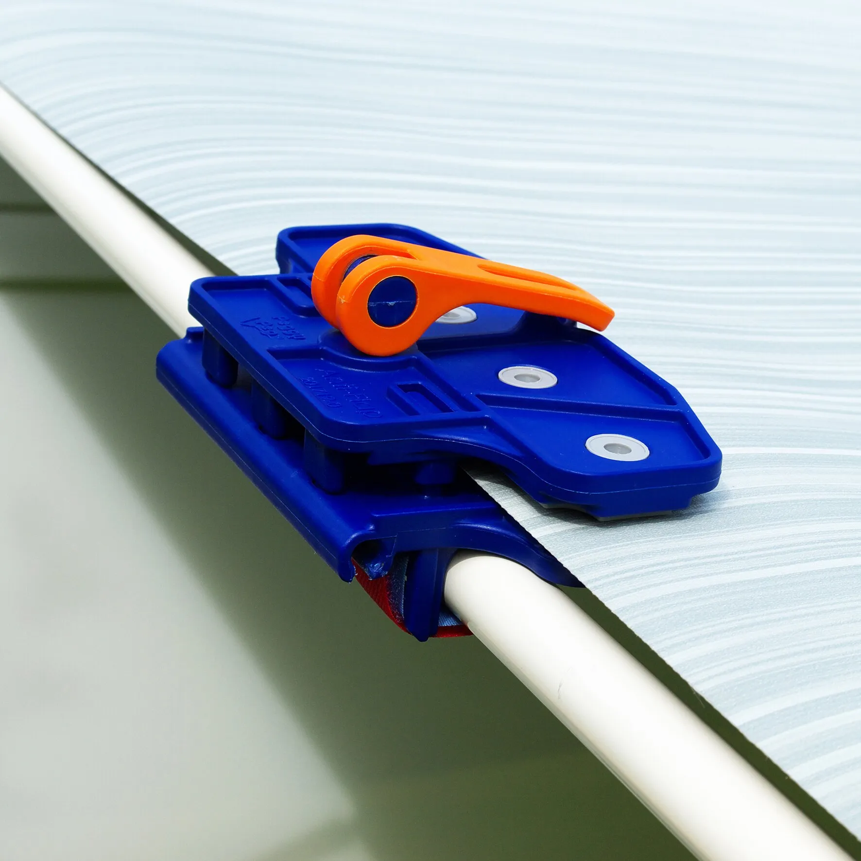 Blaue PP-Markisenklemme Fix&Go AntiFlap mit orangefarbenem Hebel an einer weißen Markisenstange befestigt