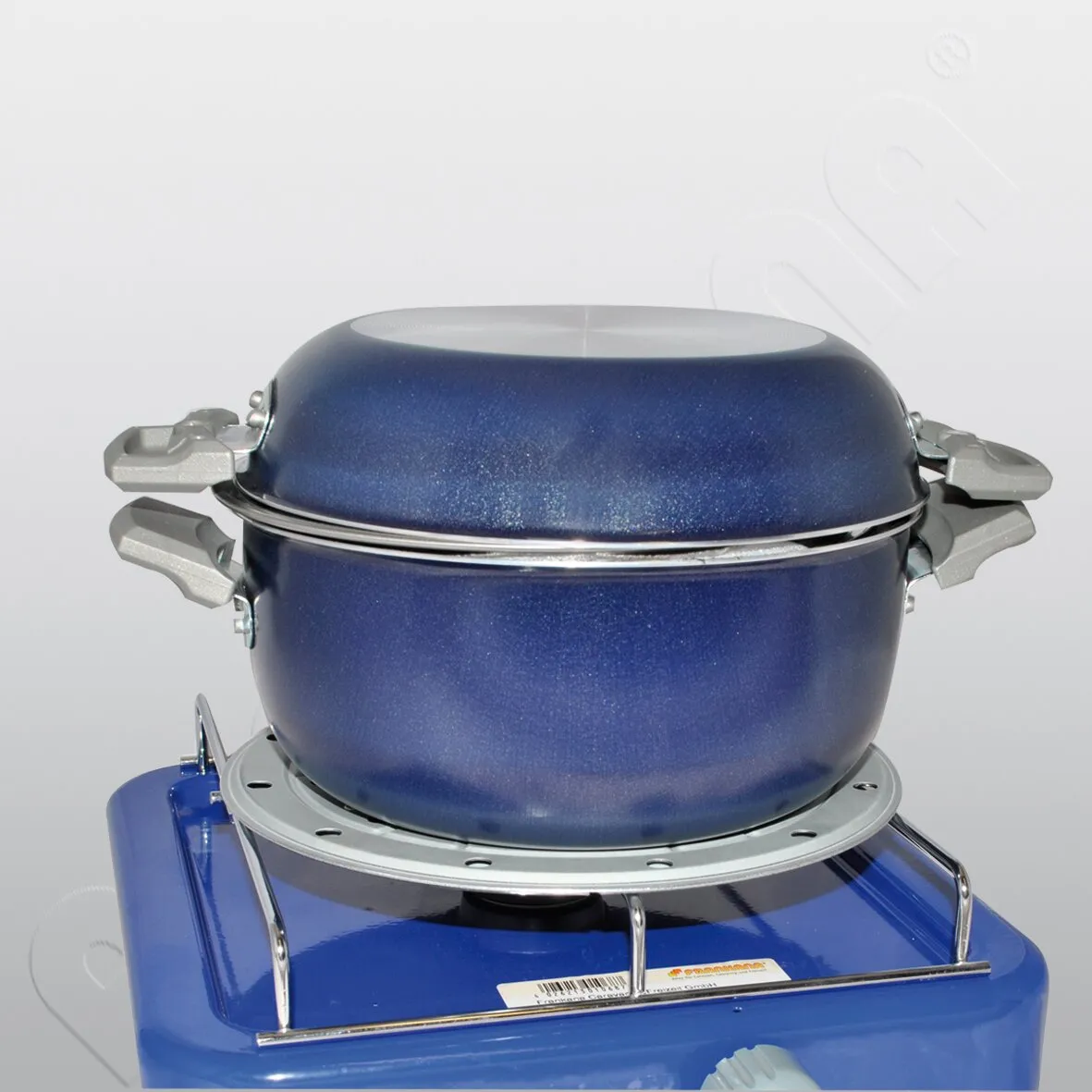 Blaue Sicherheitskochplatte mit 16 cm Durchmesser und darauf stehendem blauem Topf mit Deckel und seitlichen Griffen
