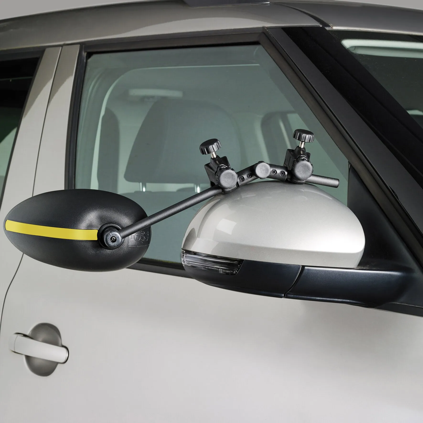 Schwarzer Caravanspiegel Speed Fix Mirror mit gelbem Streifen, an einem weißen Fahrzeugaußenspiegel befestigt