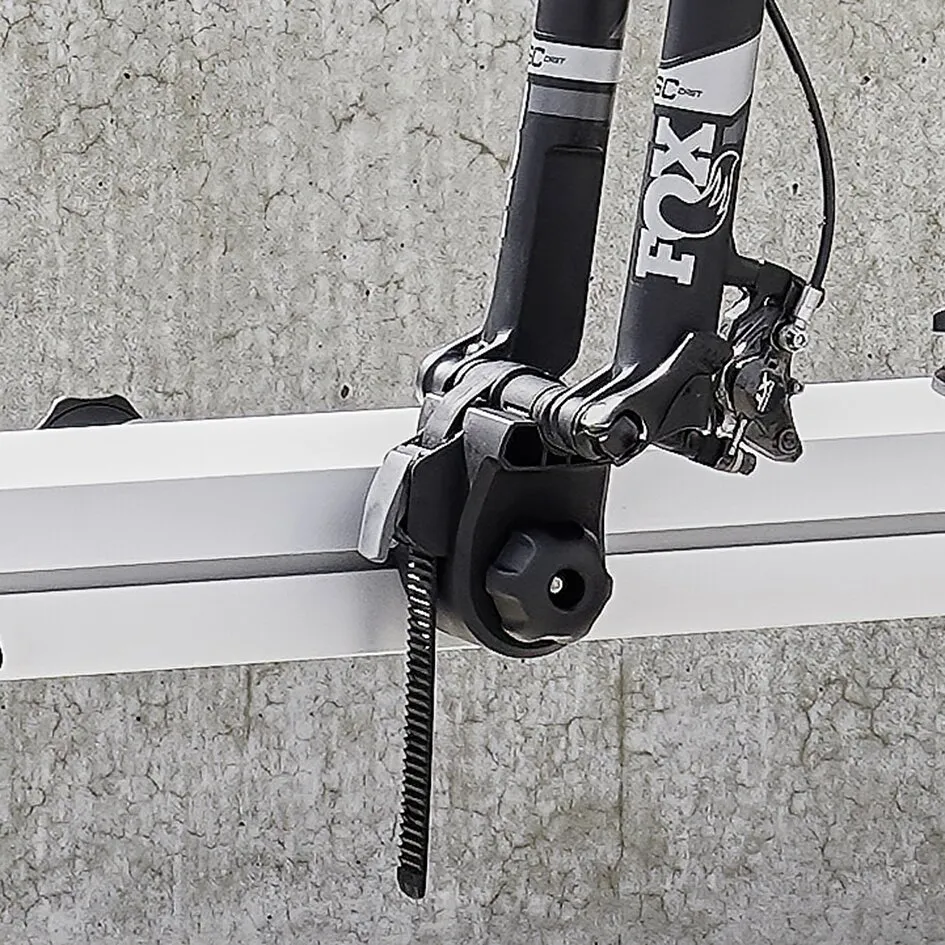 Schwarzes Fork Mount Adapter Kit für Steckachsen an einer Fahrradgabel, montiert auf einem weißen Fahrradträgeraufsatz