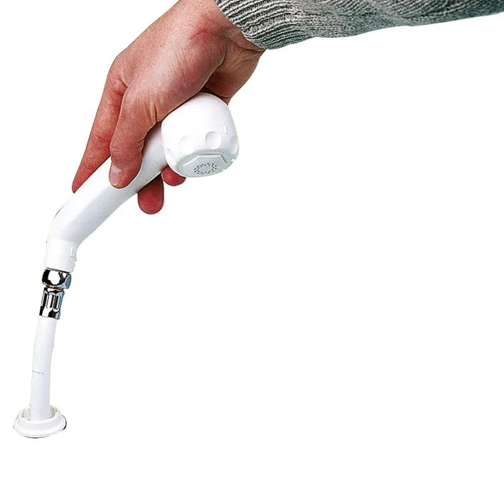 Weiße Handbrause mit sichtbarem Schlauch und Wandhalter, von einer Hand gehalten, vor weißem Hintergrund