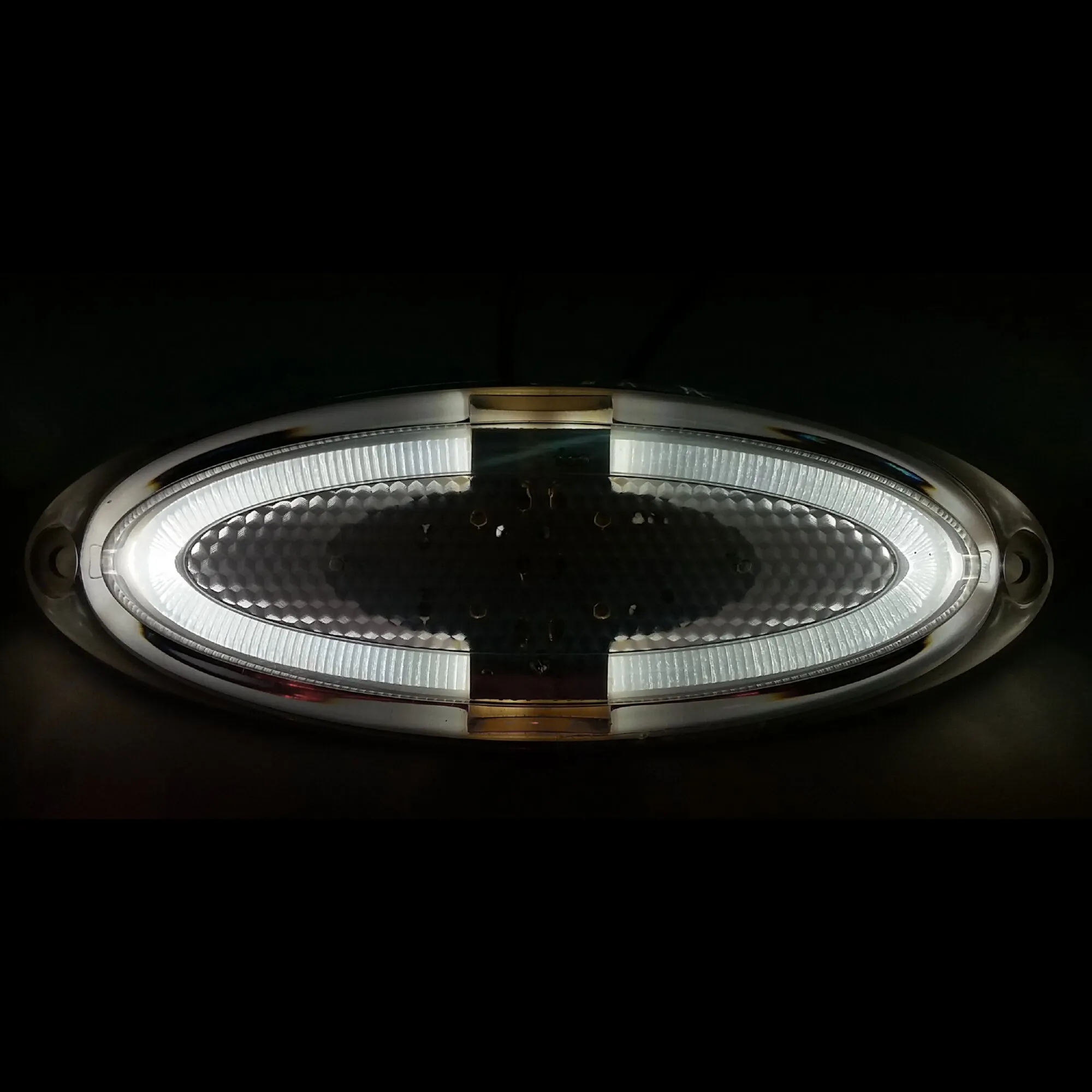 Ovale weiße Markierungsleuchte mit geriffelter Streuscheibe, Wabenreflektor und seitlichen Befestigungsösen