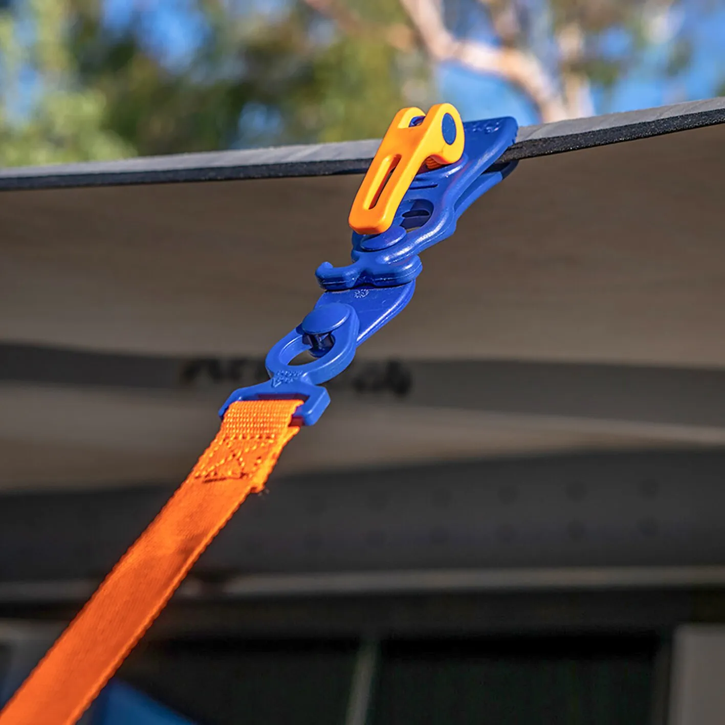 Blau-oranger U-Connector aus Kunststoff verbindet ein orangefarbenes Markisenband mit einer Markisenkante
