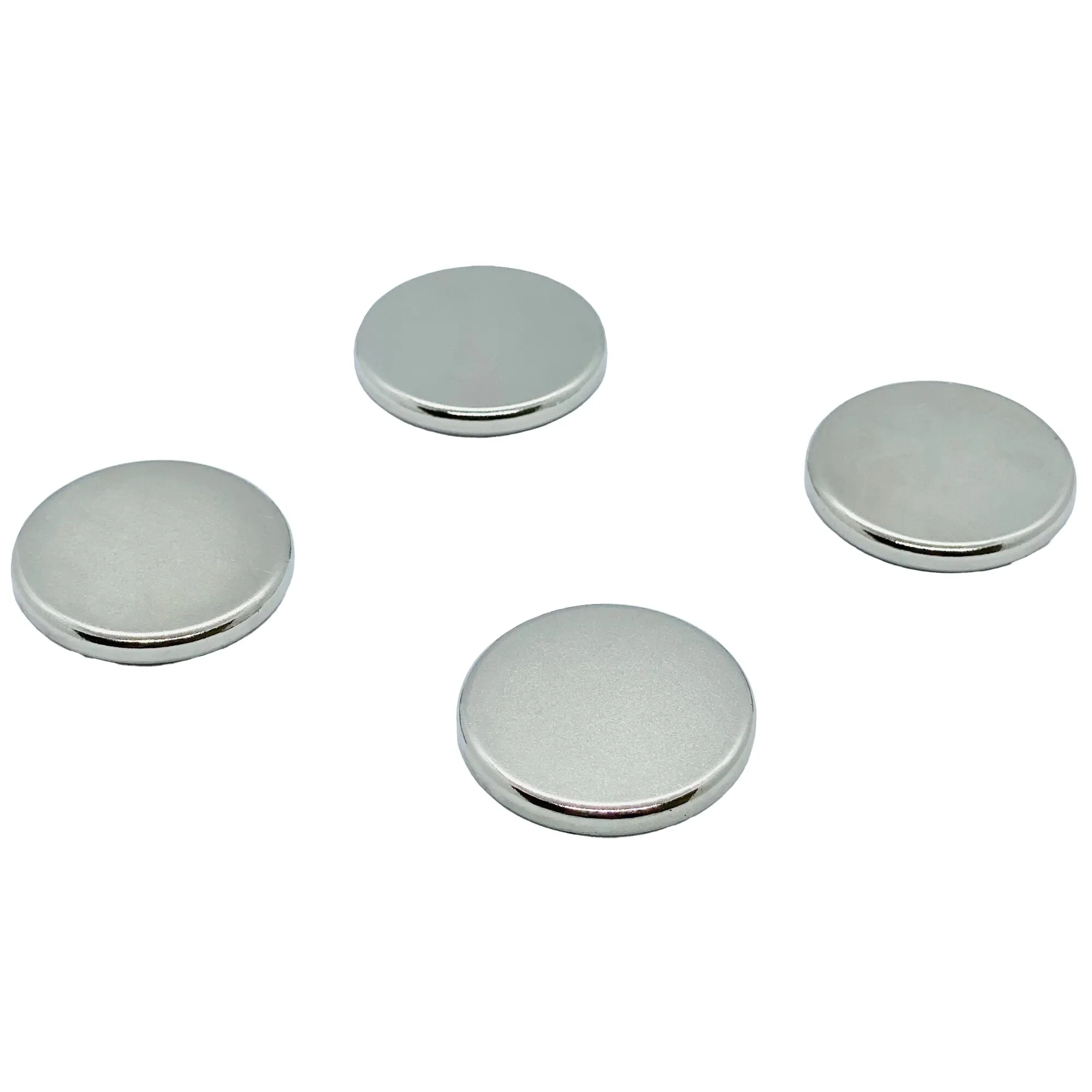Mehrere runde silberfarbene Power-Magnete aus Metall liegen locker auf weißem Hintergrund