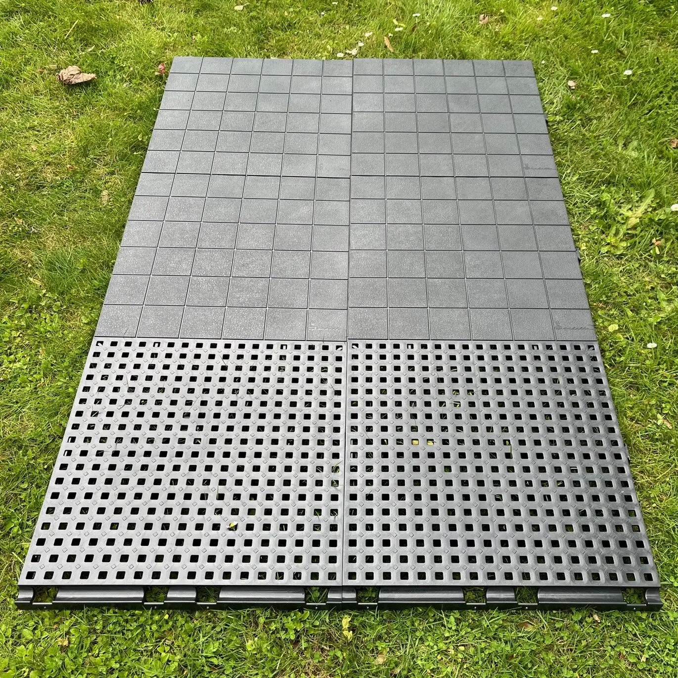 IsabellaFloor gelochte Bodenfliese, 50 x 50 cm, graue Quadratfliesen auf Gras, obere Fläche mit feinem Raster und unten perforierte Platten
