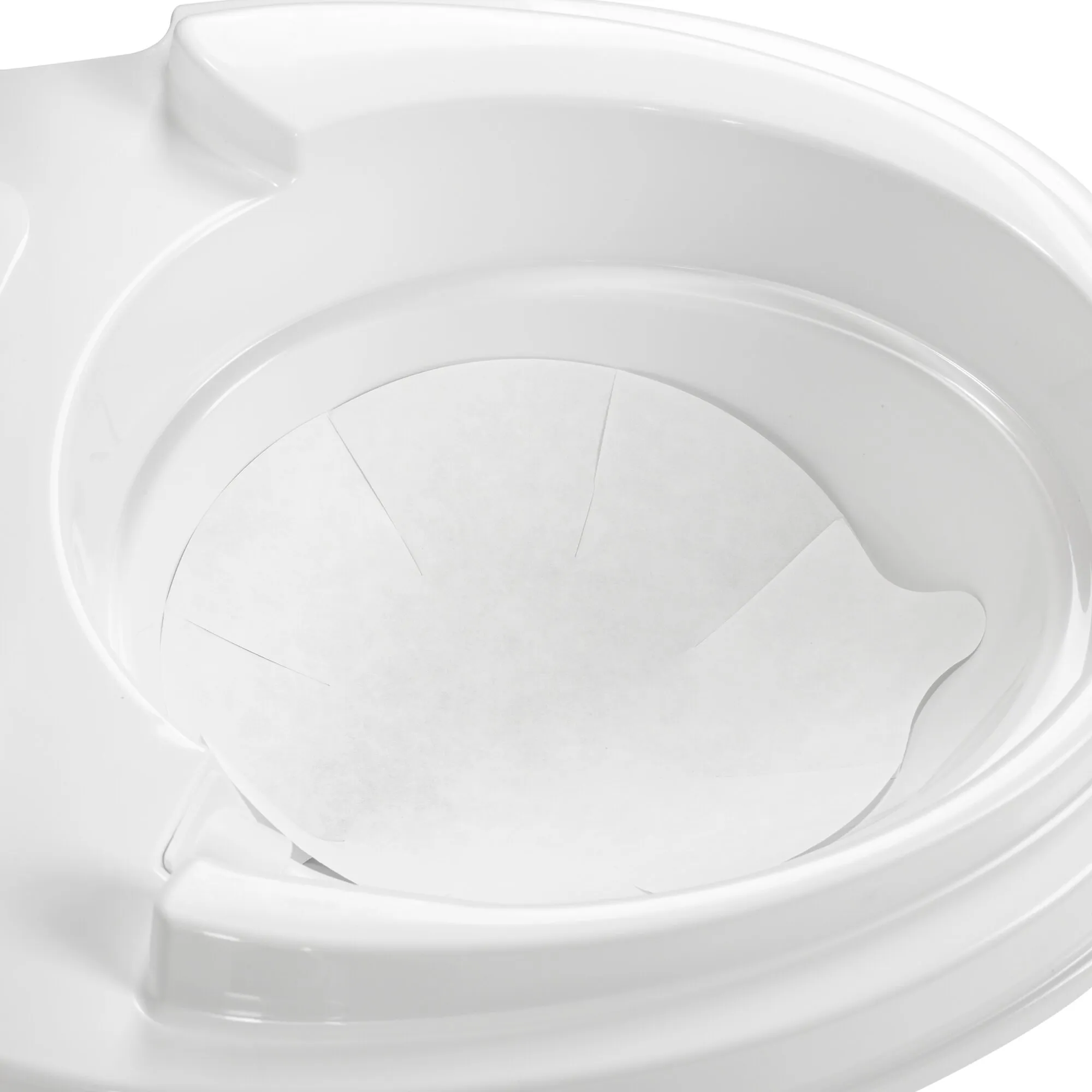 Weiße Toilettenschüssel mit eingelegter, runder Toiletten-Einlage aus weißem saugfähigem Material