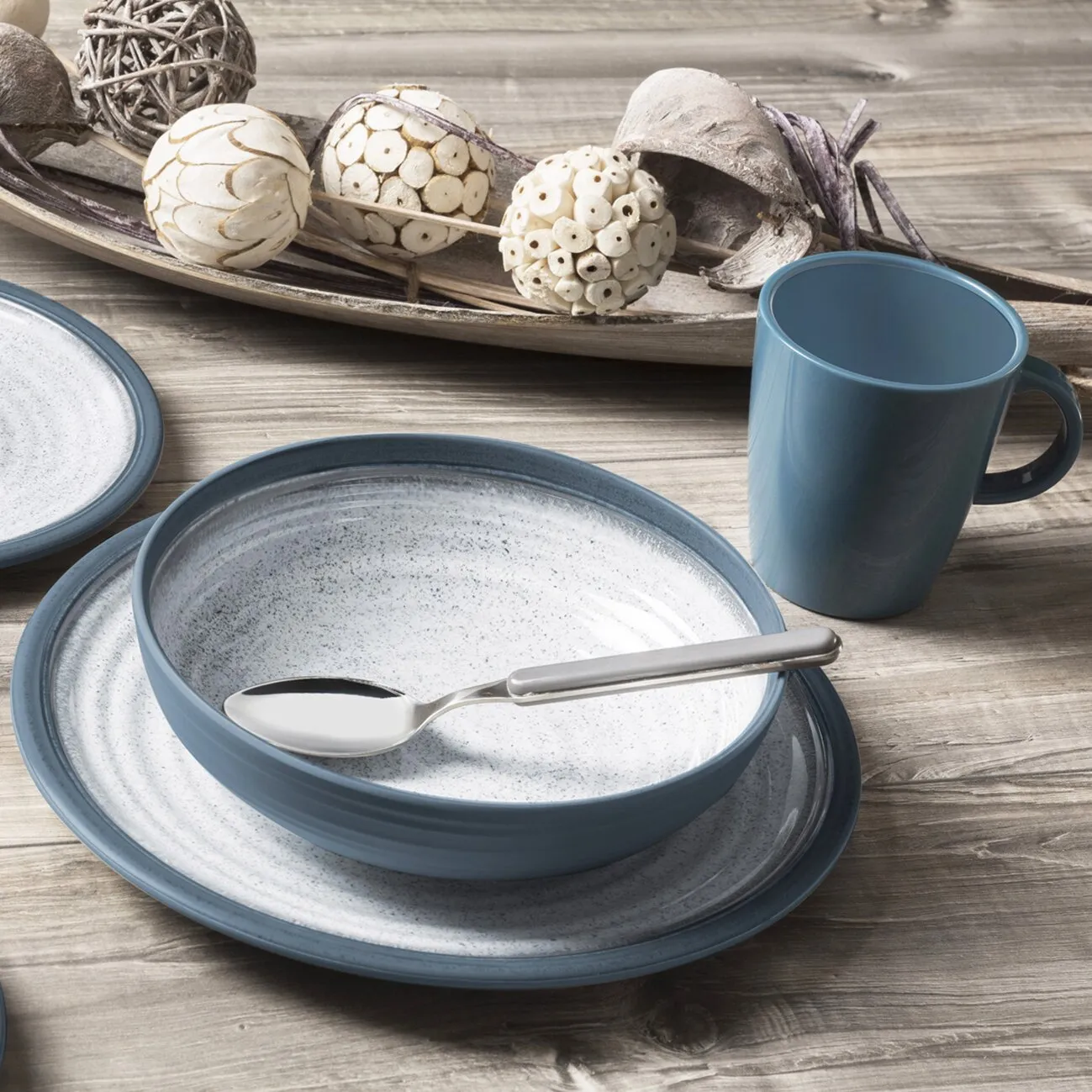 Tuscany 16-teiliges Geschirrset in Blau mit Tellern, Schale und Tasse auf Holztisch, Löffel in der Schale