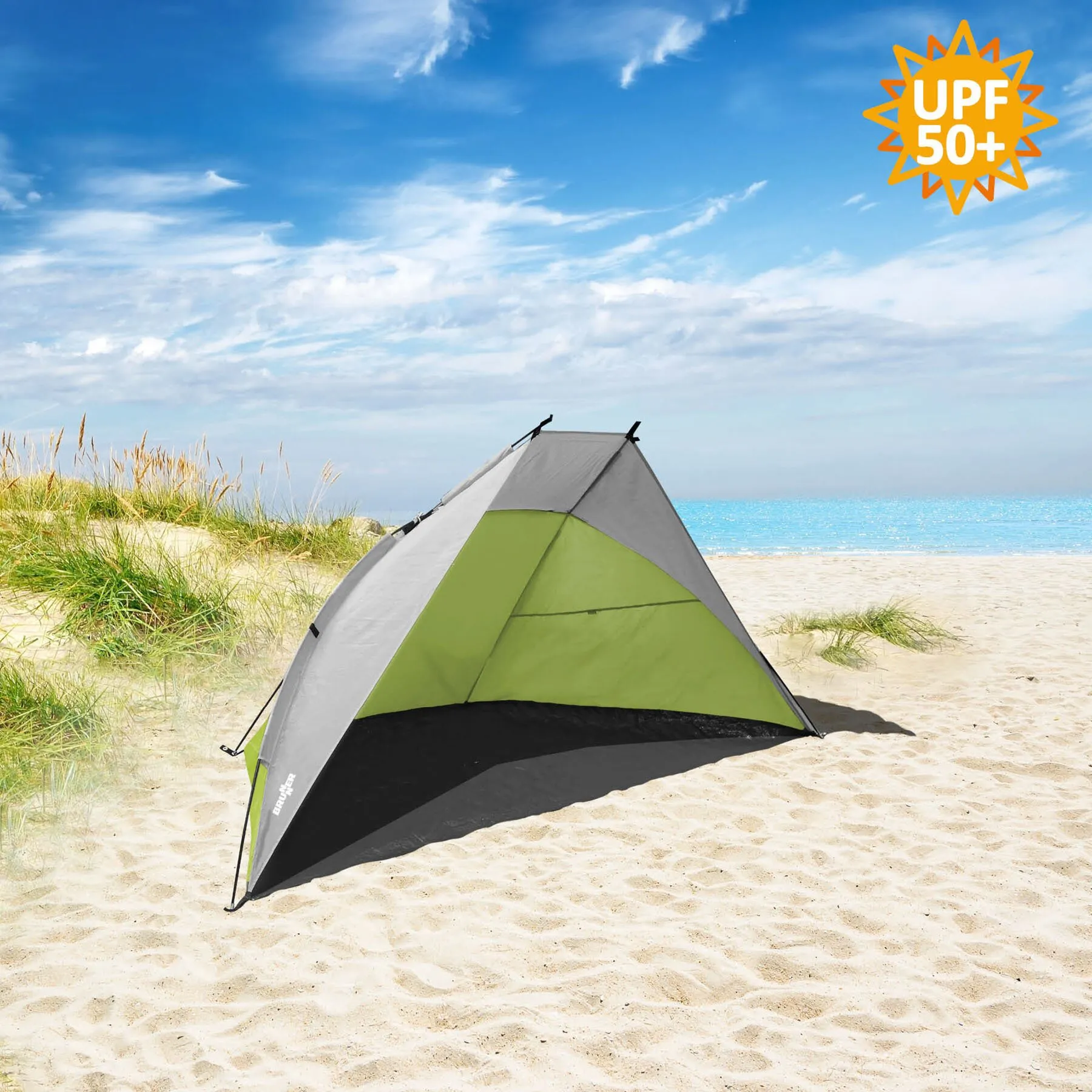 Graugrüne Strandmuschel Tonga mit schwarzem Boden auf Sandstrand vor Dünen und Meer, mit UPF-50+-Hinweis