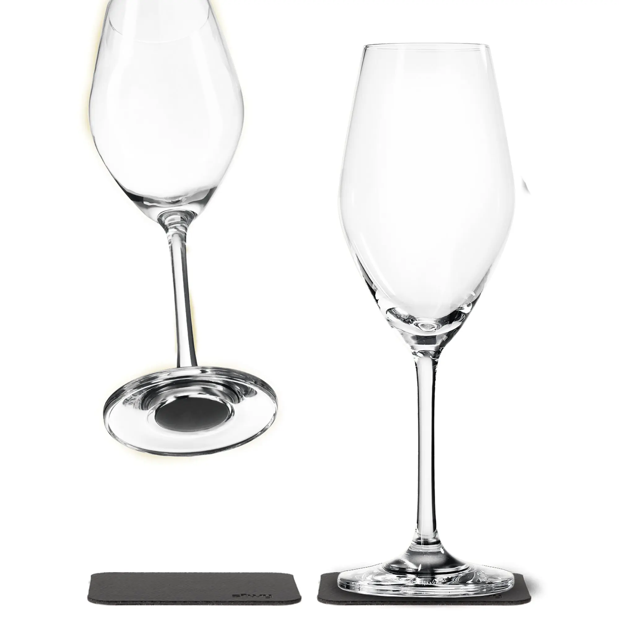 Zwei klare Champagnergläser mit Stielen stehen nebeneinander, leer, auf dunklen Steinuntersetzern; Kristallglasstruktur, helle Lichtreflexe