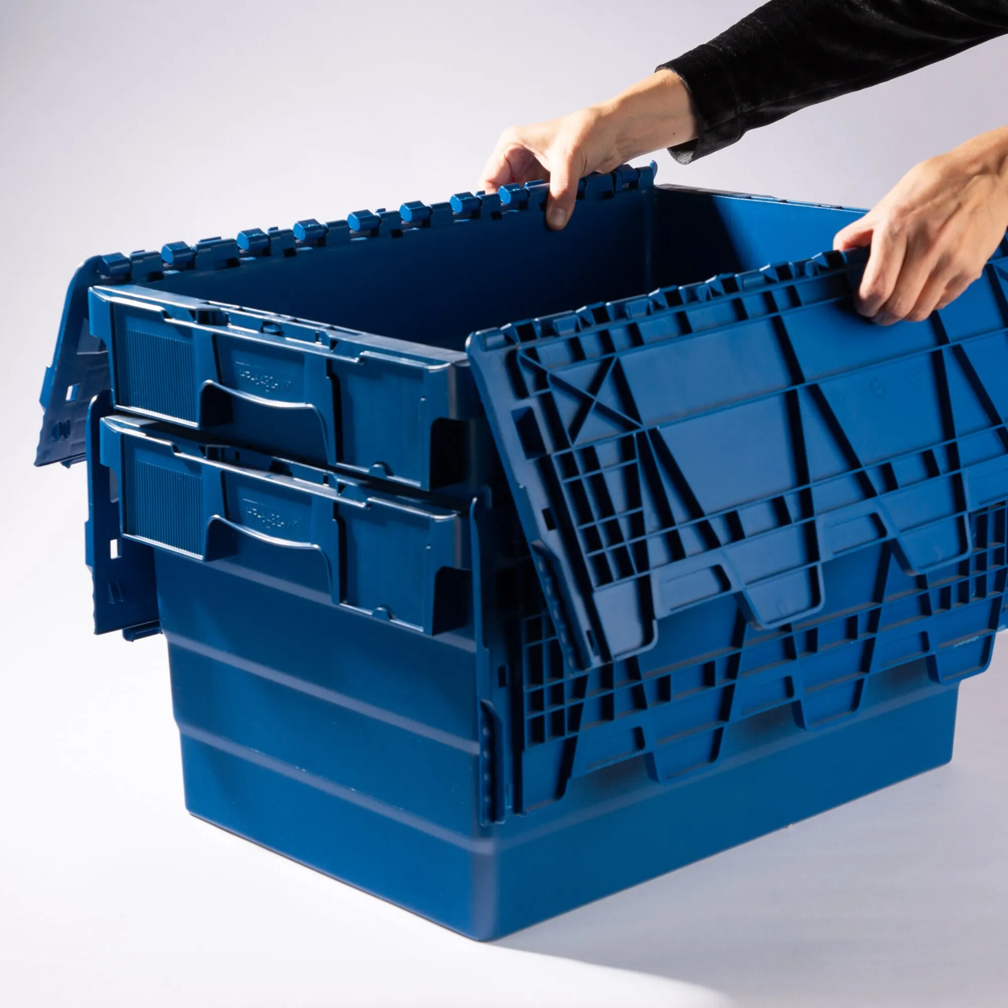 Blaue Transportbox FF mit 60 Litern Volumen, geöffnet und von zwei Händen auseinandergeklappt dargestellt