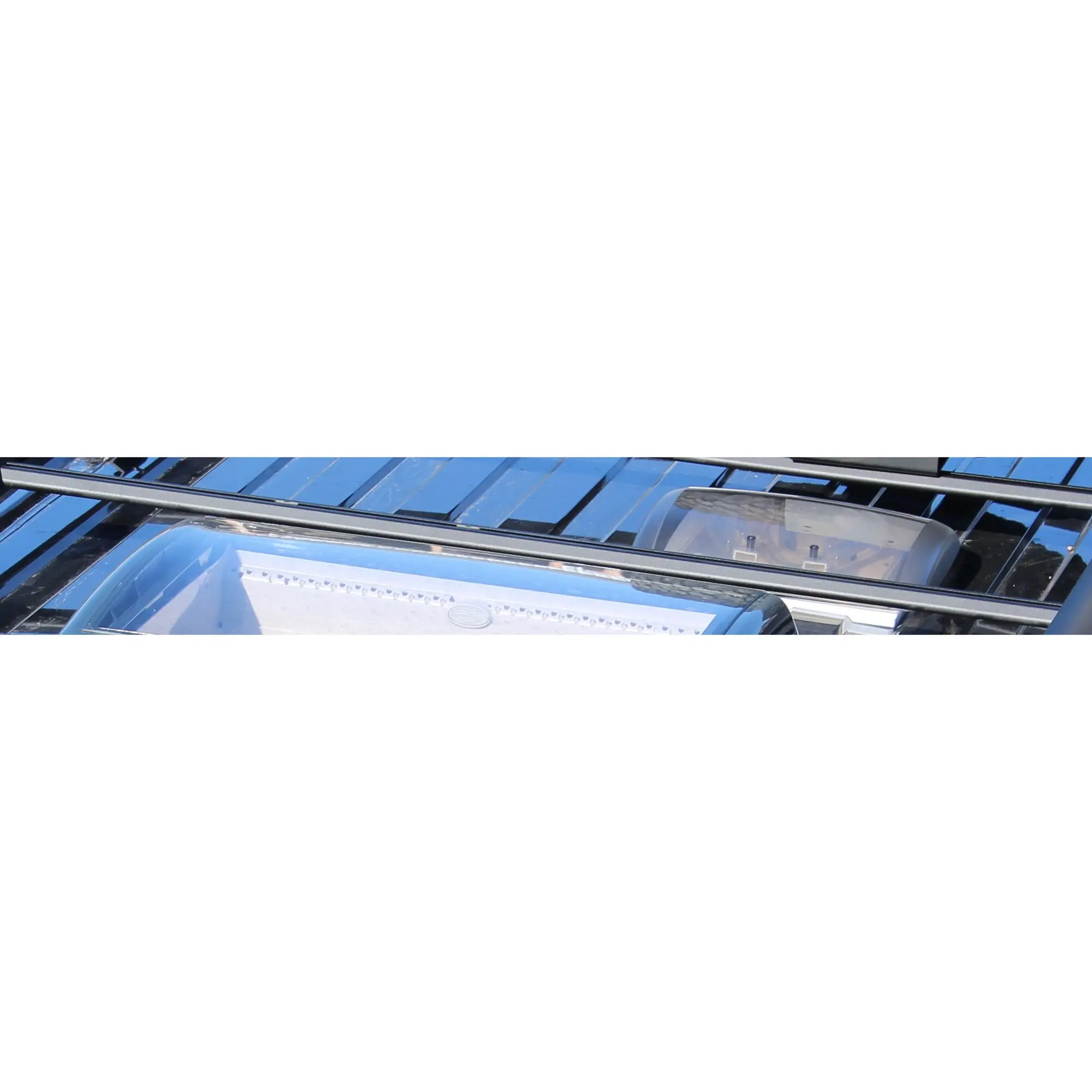 Horizontale schwarze Querträger des Adventure Roof Dachgepäckträgers auf dem Dach eines VW T5/T6, sichtbare Trägerrohre und Befestigungselemente