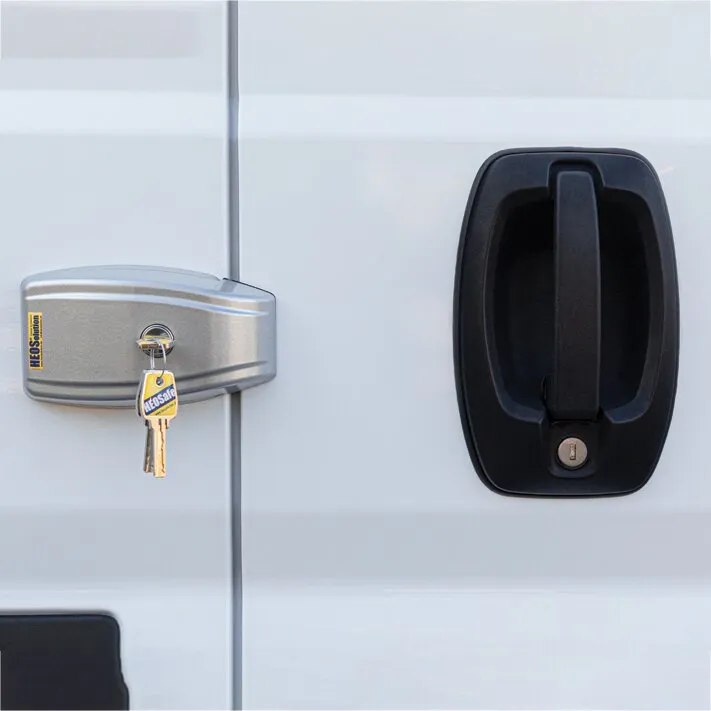 Silbergraues HEOSystem VAN Türschloss an einer weißen Fiat-Ducato-Tür neben schwarzem Türgriff mit eingestecktem Schlüssel