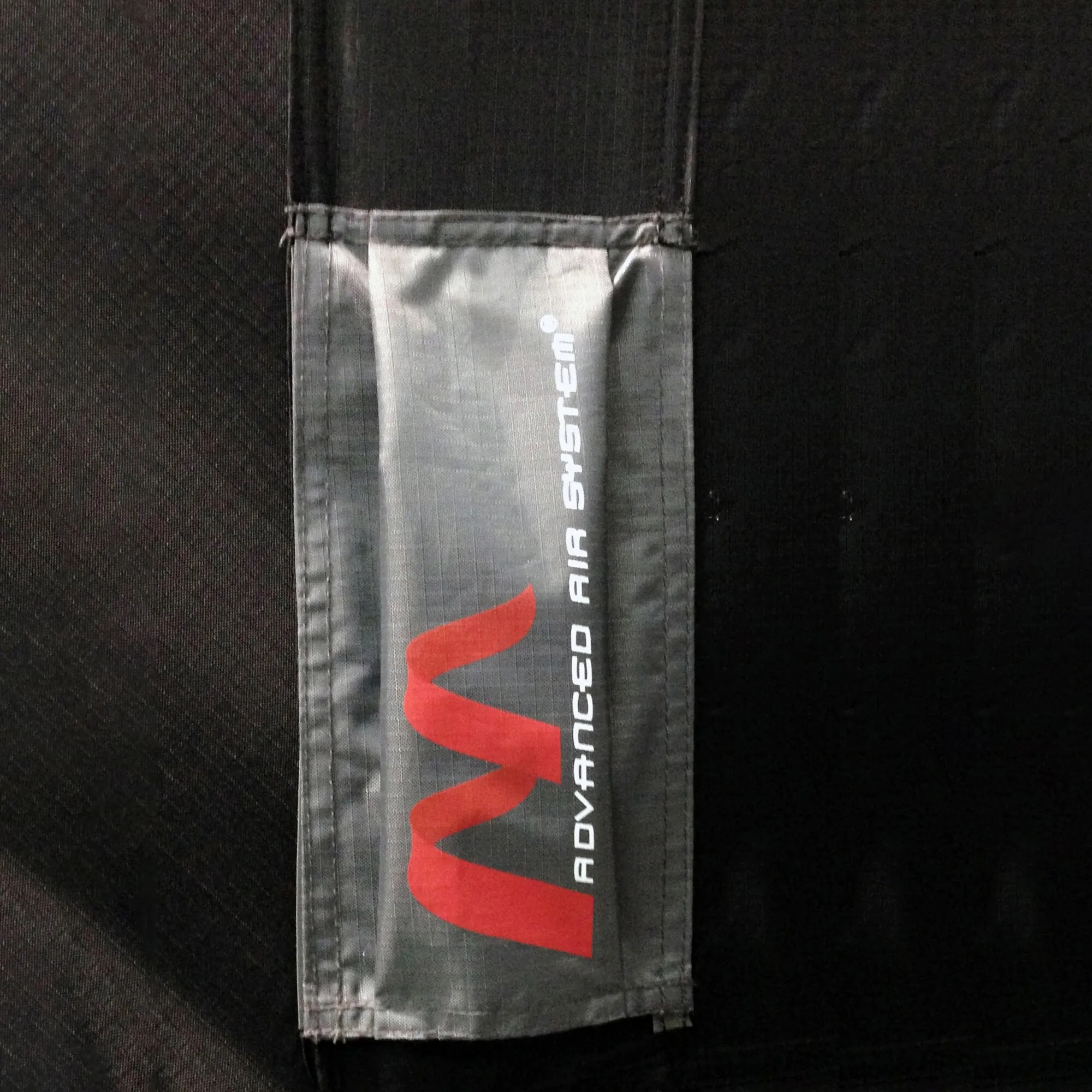 Detailaufnahme des grauen Stoffsegments eines AAS-Systems Dorado Pro 400 mit rotem Logo und weißem Adventure-Air-System-Schriftzug
