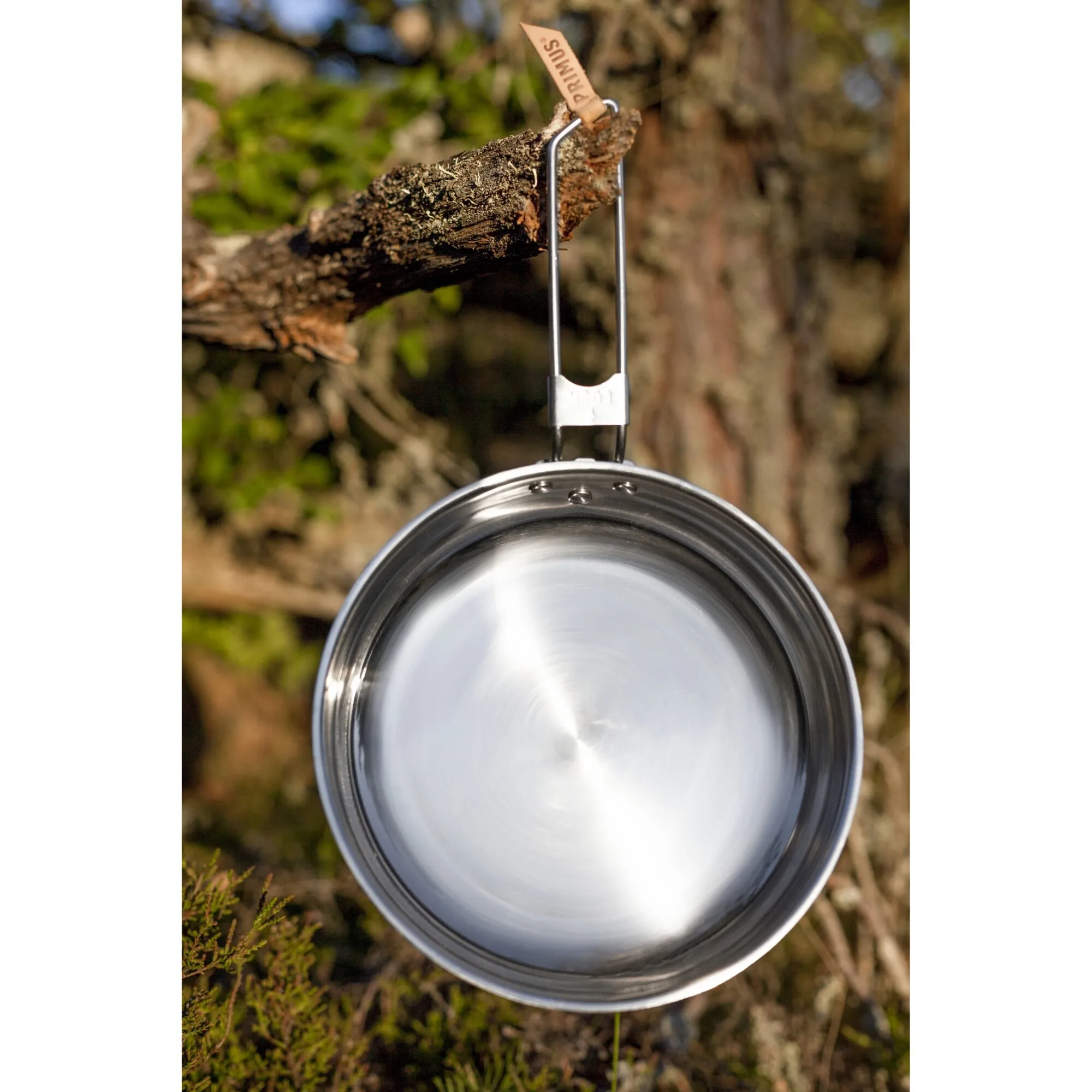 Edelstahlpfanne Campfire, 25 cm, hängt mit klappbarem Drahtgriff an einem Ast im Wald
