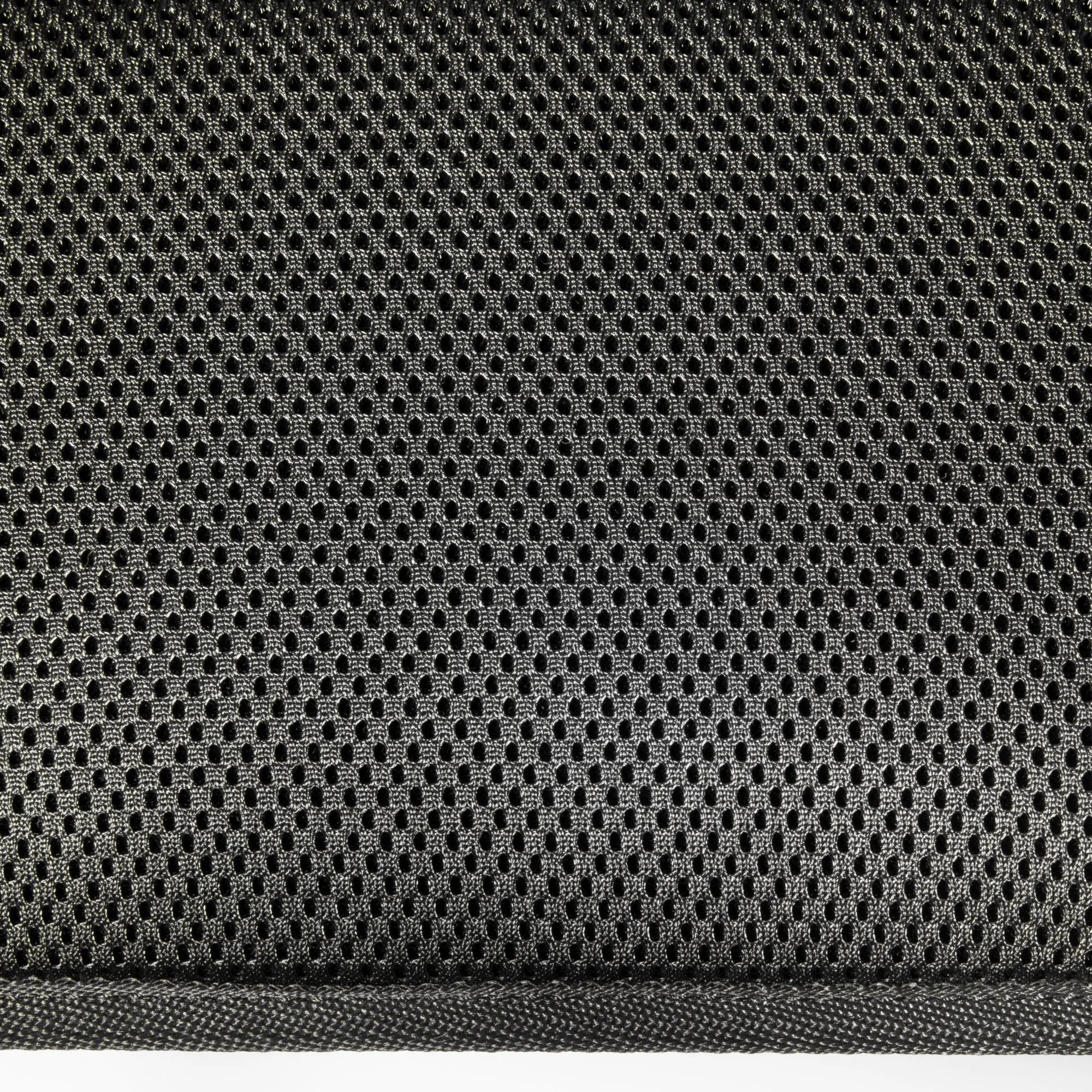 Detailaufnahme des schwarzen Bezugsstoffs eines Campingstuhls mit dichtem, regelmäßig perforiertem Gewebe