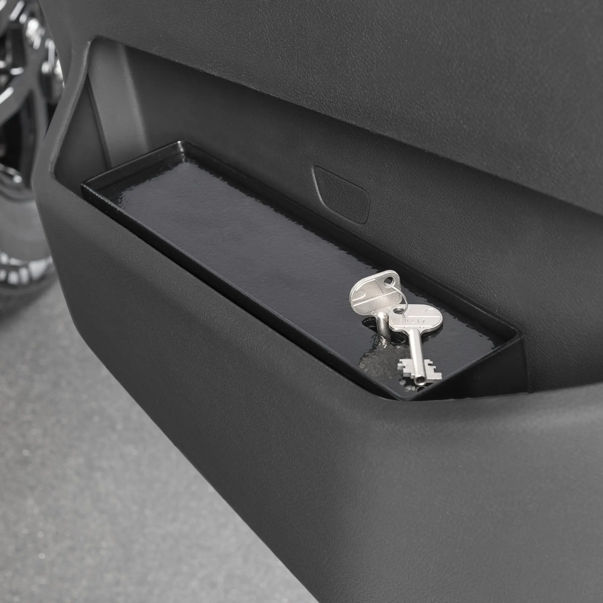 Nahaufnahme des Türfachs der Beifahrerseite des Ford Transit ab Modelljahr 06/2019; offenes Fach mit glatter Innenfläche und Schlüssel daneben