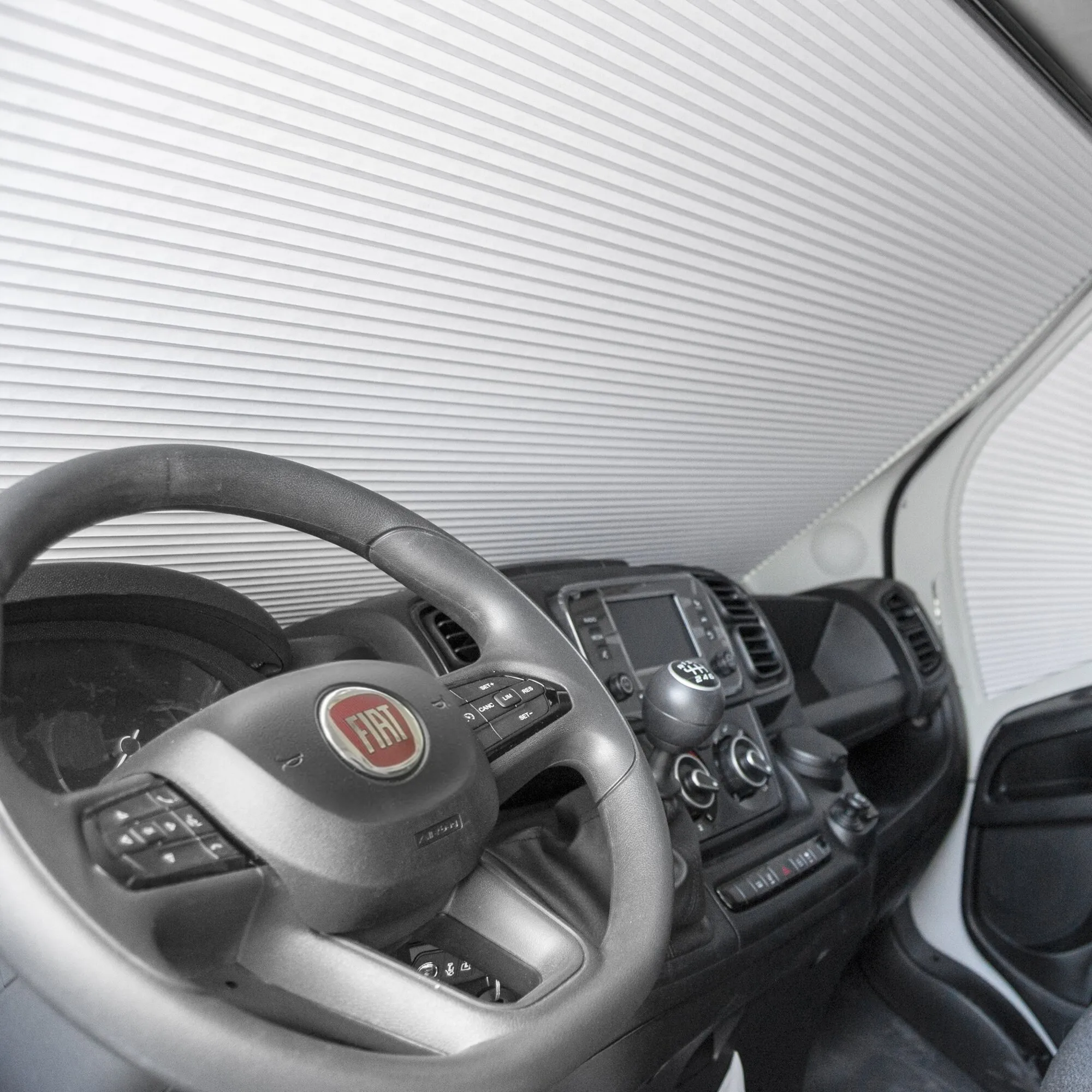 Innenansicht eines Fiat Ducato mit montierter darkStar-Frontscheibenverdunkelung aus weißen Plisseefalten