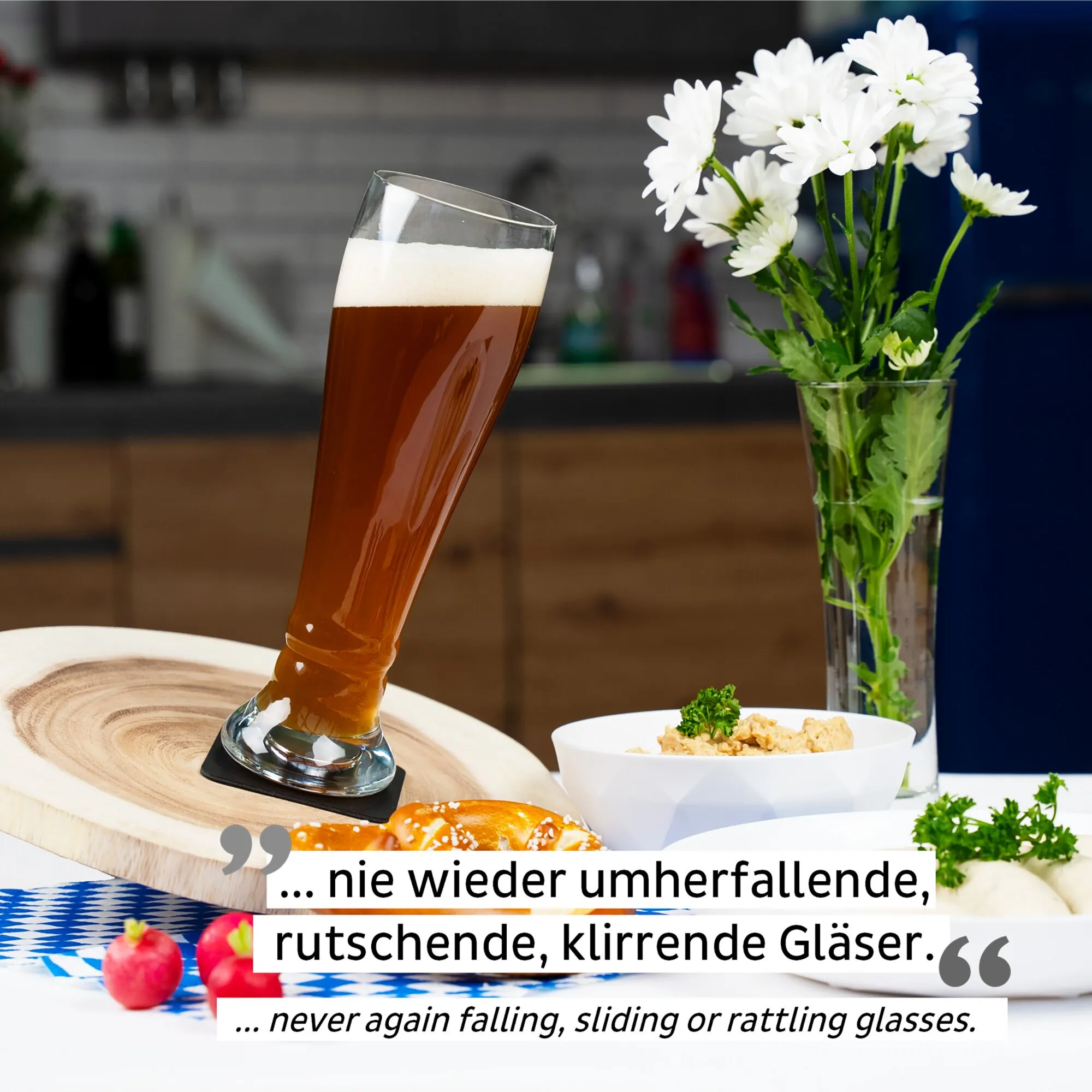 Schräg stehendes Magnet-Kristallglas als Weißbierglas mit bernsteinfarbenem Bier und Schaum, daneben Blumen und Snacks auf dem Tischwaswo