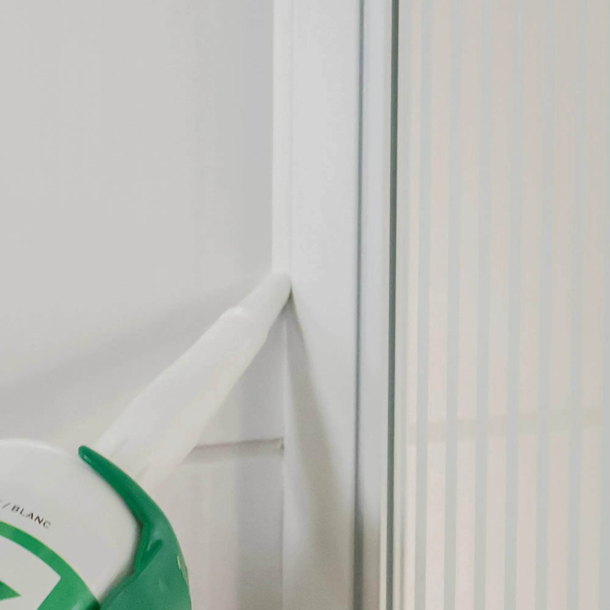 Dichtstoff XSEAL EXTREME wird als weiße Fuge an der Verbindung zwischen Wand und Fensterrahmen aufgetragen