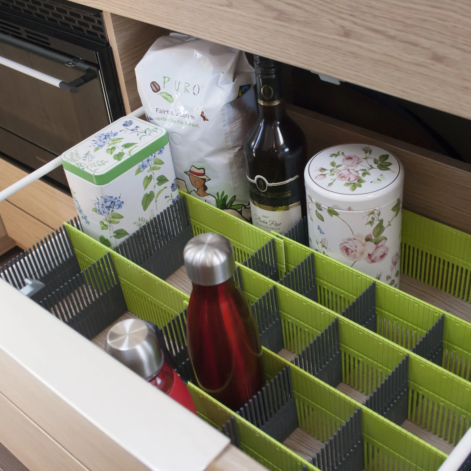 Limefarbene Stauleiste 100 MAXXI mit grauen Trennstäben ordnet Flaschen, Dosen und Packungen in einer Küchenschublade
